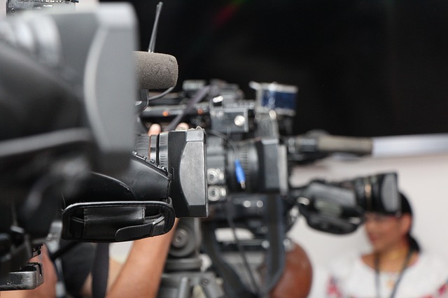 Press and media - TV camera crew filming a female presenter