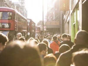 crowd of people walking through streets in london featured